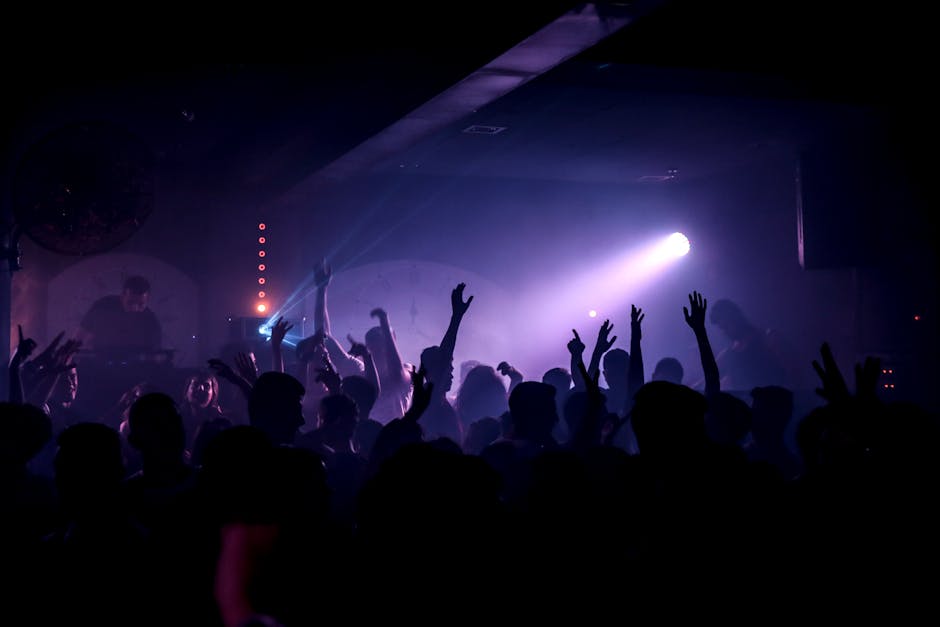 Energetic crowd dancing in a lively nightclub under spotlights